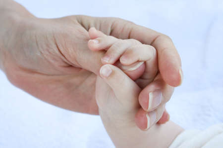closeup little baby holding motherの写真素材