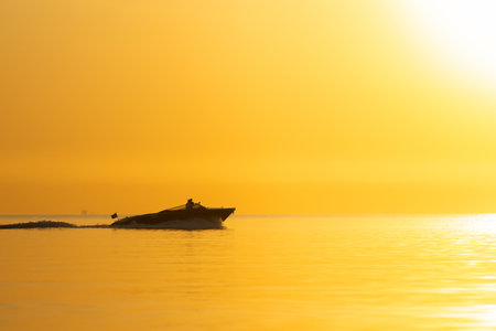 Silhouette of a boat in the sea at sunset time.