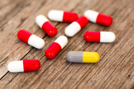 Pills of medicine on wooden background.