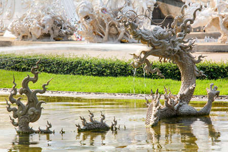 Thai Myth Dragon Sculpture Splashing Water in Wat Rong Khun, Thailandの写真素材