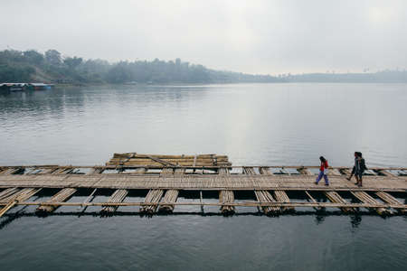 Kanchanaburi, Thailand - December 09, 2013: Temporary Bridge of Saphan Mon (Mon Bridge) across Song Karia River due to heavy flood damaged the old wooden bridge, in the morning in Sangklaburi Districtのeditorial素材