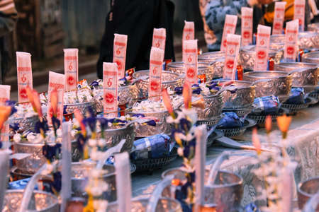 Kanchanaburi, Thailand - December 09, 2013: Sets of Alms Prepared for Buddhist Monk in the Morning at Sangkhlaburi's Mon Village including Incense, Rice, Prepared Foods, Drinksのeditorial素材