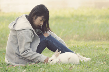 Vintage Child and Her Pet Bunny Playing Outdoorsの写真素材