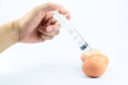 Vaccination of eggs with syringe injection in handの写真素材