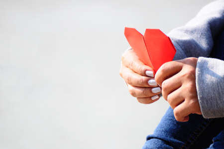 Hands Holding a Red Heart Shape Paperの写真素材