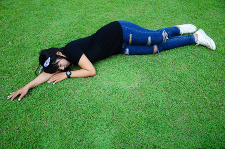 Tired Girl Sleep on grass in the Gardenの写真素材