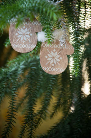 Wooden Christmas ornaments hanging on a fir tree branch.の写真素材