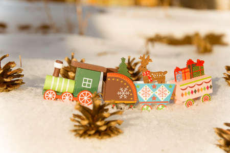 Wooden toy train with Christmas decorations in the snow. Christmas background.の写真素材