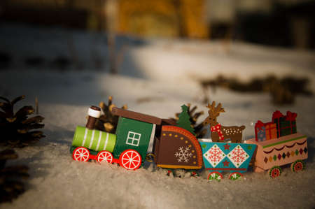 Wooden train in the snow with christmas decorations. Christmas and New Year concept.の写真素材
