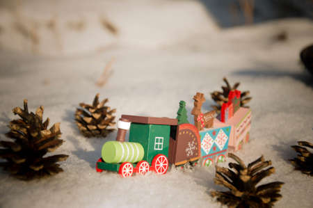 Christmas decoration with wooden train in the snow. Christmas greeting card.の写真素材