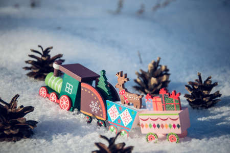 Wooden toy train with Christmas decorations in the snow. Selective focus.の写真素材