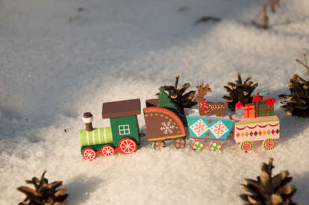 Wooden toy train with Christmas decorations in the snow. Christmas background.の写真素材