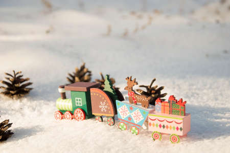 Wooden toy train with christmas decoration on snow. Christmas backgroundの写真素材