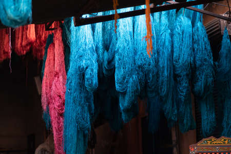 Dyed wool hanging to dry in souk in Marrakech Morocco, red, blue, yellow, gold