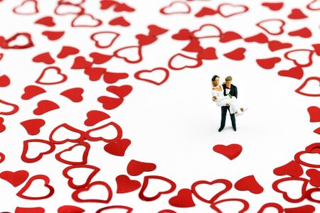 Miniature wedding couple in a sea of heartsの写真素材
