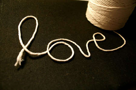 Love spelled in string with the spool next to it.