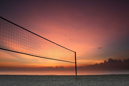 Sillhouette of a volleyball net against sunrise on the beachの写真素材