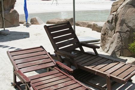 Wooden deck chairs tropical setting next to water