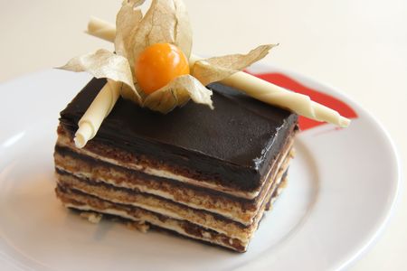 Layered opera chocolate cream cake garnished with flower