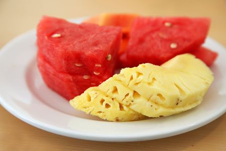 Slices of tropical fruits on plate: watermelon, pineapple, papayaの写真素材