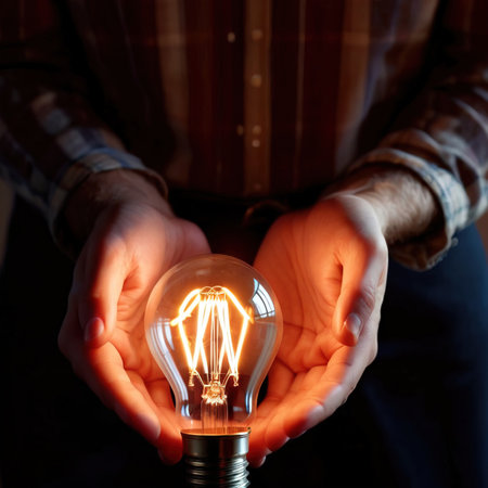 Hands holding bright glowing lightbulb, a metaphor for grapsing inspiration and future ideasの素材
