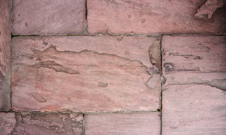 red stone tile texture or background. Detail of natural stone Sandstone red-brown tones close-up....
