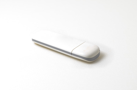 USB portable modem. Used to connect internet by using simcard. Shoot over white background. Shallow depth of field. Focus on the closes distance.の写真素材
