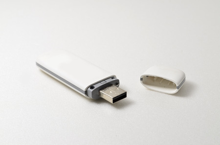 USB portable modem. Used to connect internet by using simcard. Shoot over white background. Shallow depth of field. Focus on the closes distance.の写真素材