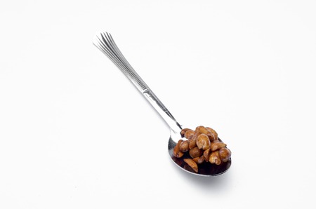 Delicious roasted nut in spoon on white backgroundの写真素材