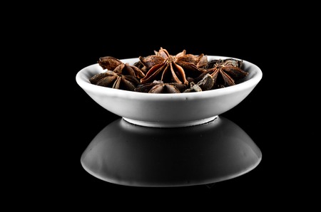 Anise spice in bowl over black background