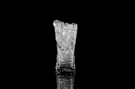 Glass with ice over black backgroundの写真素材