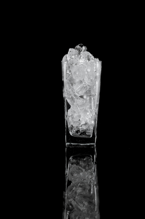 Glass with ice over black backgroundの写真素材
