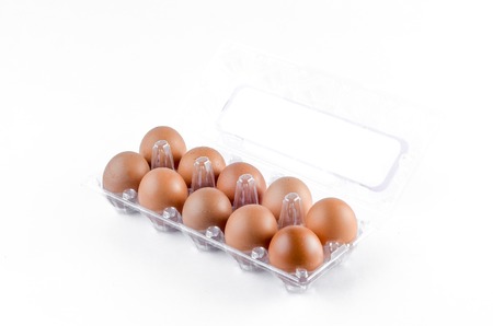 Chicken egg in tray over white backroundの写真素材