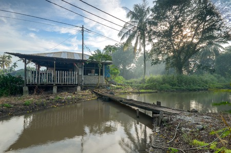 Ray of light with river, forest and  house with wooden fenceの写真素材