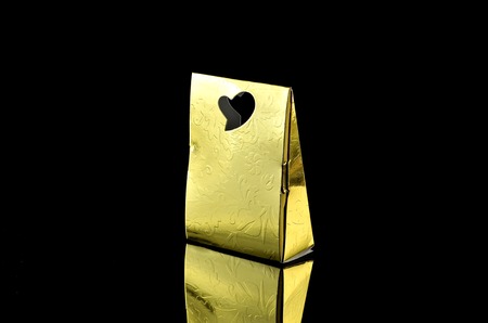 Triangle golden box for special gift over black backgroundの写真素材