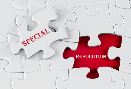 White puzzle with void in the middle when one piece of the puzzle is taken out with text written Special Resolutionの写真素材