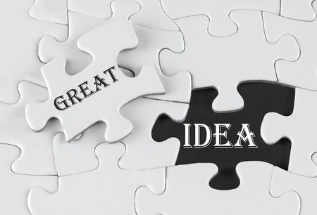 White puzzle with void in the middle when one piece of the puzzle is taken out with text written Great Ideaの写真素材