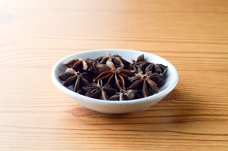 Anise spice in bowl over wooden backgroundの写真素材