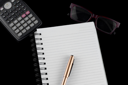 Business concept - Office desk with White ring book, pen, glasses, and calculator. Space for text available.の写真素材