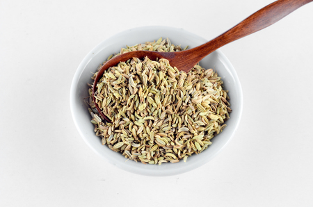 Aniseed Spice in white bowl with wooden spoon over white backgroundの写真素材
