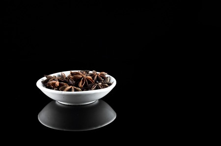 Anise Spice in white bowl over black backgroundの写真素材