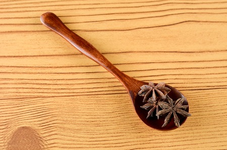 Anise Spice in wooden spoon over wooden backgroundの写真素材