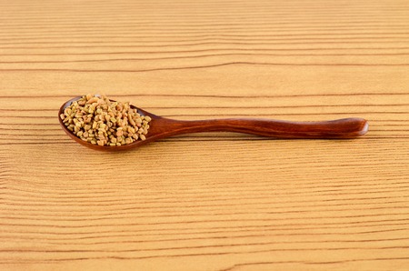 Fenugreek Spice in wooden spoon over wooden backgroundの写真素材