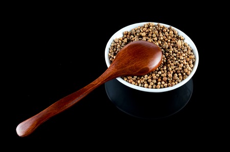 Spice seed  in white bowl with wooden spoon over black backgroundの写真素材