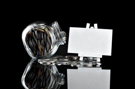 Money in container with white board for text space over black backgroundの写真素材