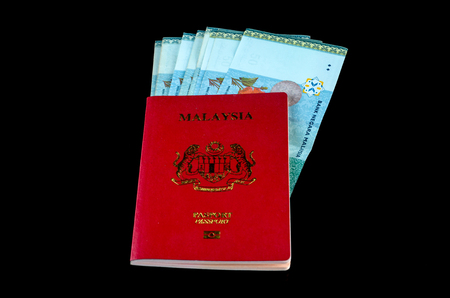 Malaysian Passport with Money over black background