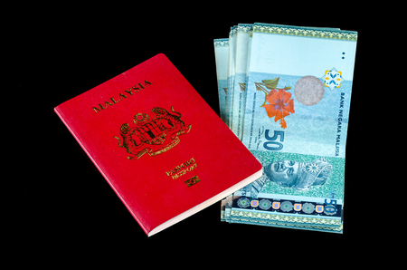 Malaysian Passport with Money over black background