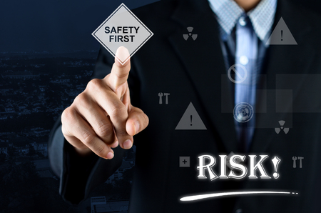 Business man pointing hand on Safety Symbol with text written Riskの写真素材