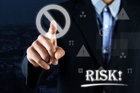 Business man pointing hand on Safety Symbol with text written Riskの写真素材