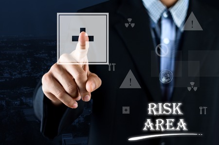 Business man pointing hand on Safety Symbol with text written Risk Areaの写真素材